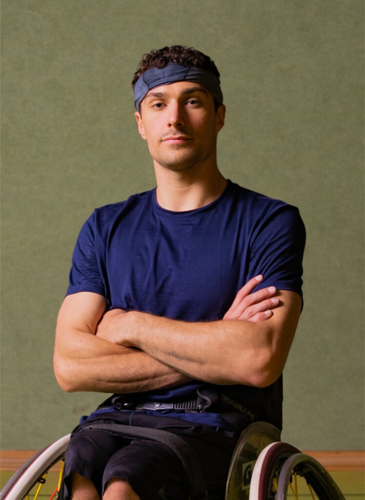 Portrait of Nico Dreimüller, a determined male athlete in a wheelchair, arms crossed. Great for content creators looking for inspiring stock footage and sound effects.